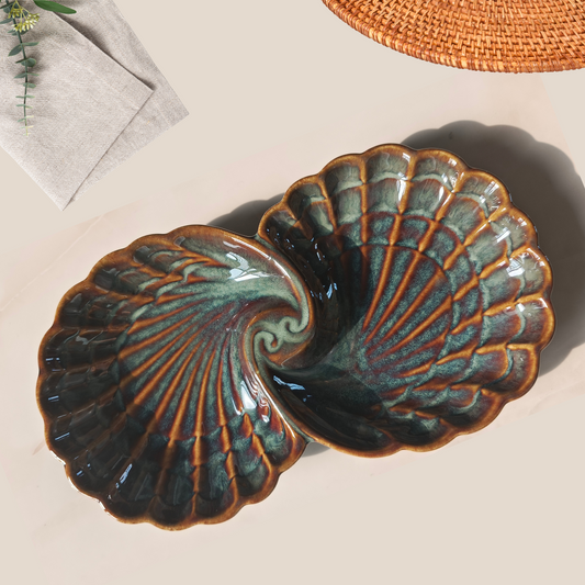 Artistic shell-shaped ceramic platter styled on a dining table in natural lighting