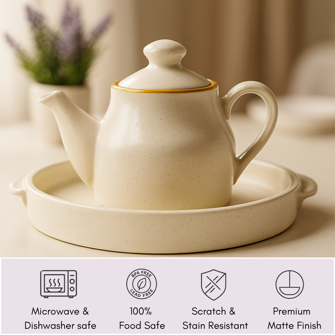Close-up of ceramic teapot on tray with icons below highlighting features—microwave and dishwasher safe, 100% food safe, scratch and stain resistant, premium matte finish.
