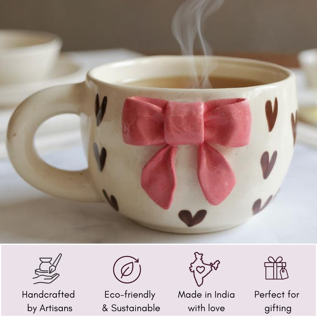 Handcrafted IndoCasa mug with pink bow and heart design, showing key features: artisan-made, eco-friendly, Made in India, gifting-ready