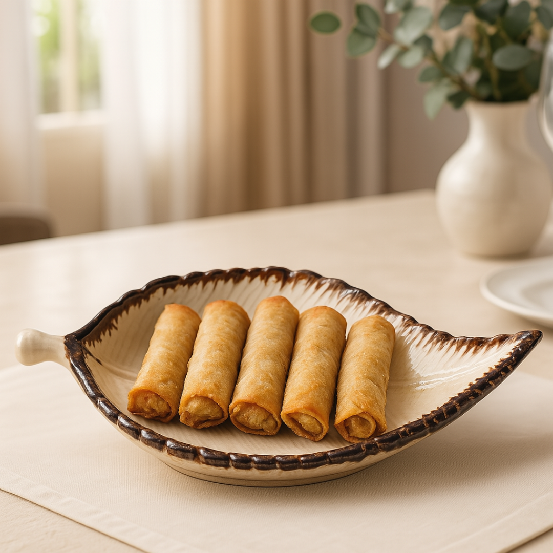 Leaf platter serving 5 golden spring rolls — styled in a cozy dining space with sunlight.